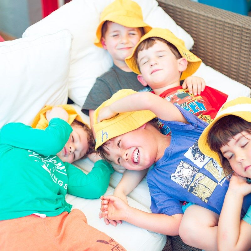 Children giggling together on a cushioned lounge